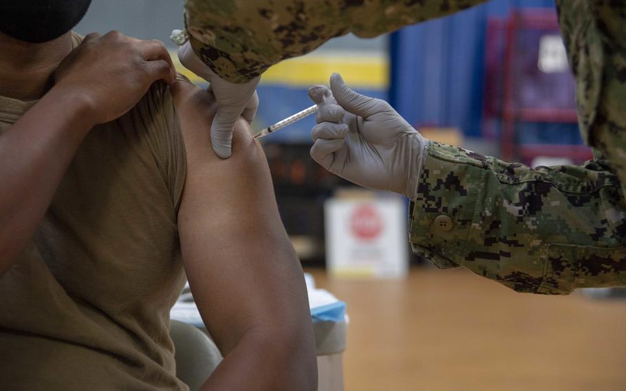 A sailor receives the coronavirus vaccine at Naval Base San Diego’s Adm. James Prout gymnasium in January 2021. 