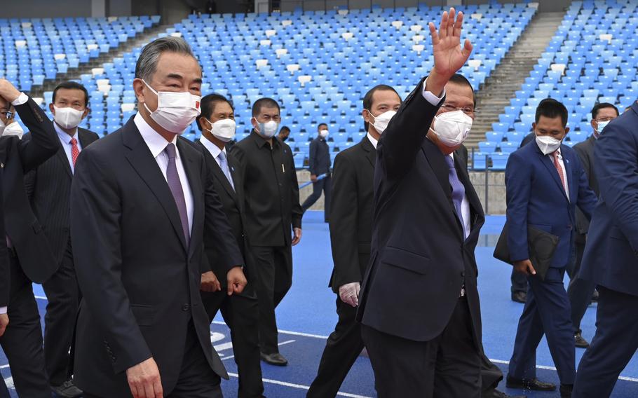 Chinese Foreign Minister Wang Yi, front left, accompanied by Cambodian Prime Minister Hun Sen, front right, walks around during a tour of the Morodok Techo National Stadium as it was handed over to the Cambodian organizing committee of the Southeast Asian Games in Phnom Penh, Cambodia, Sunday, Sept. 12, 2021. Wang is visiting Cambodia, where he met with Hun Sen and other officials to discuss COVID-19 and other regional issues.