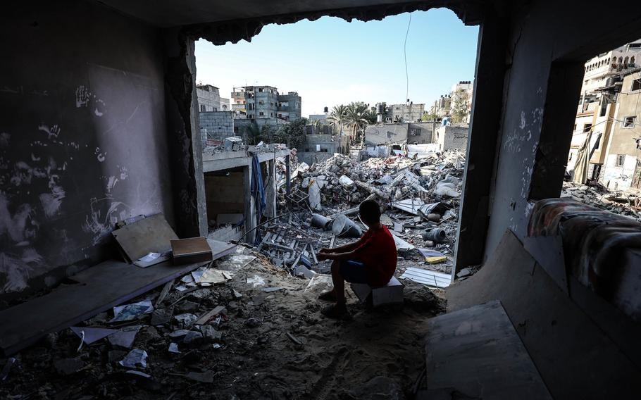 A child sits among rubble on Oct. 30, 2023, after Israeli airstrikes targeted Khan Younis in southern Gaza.