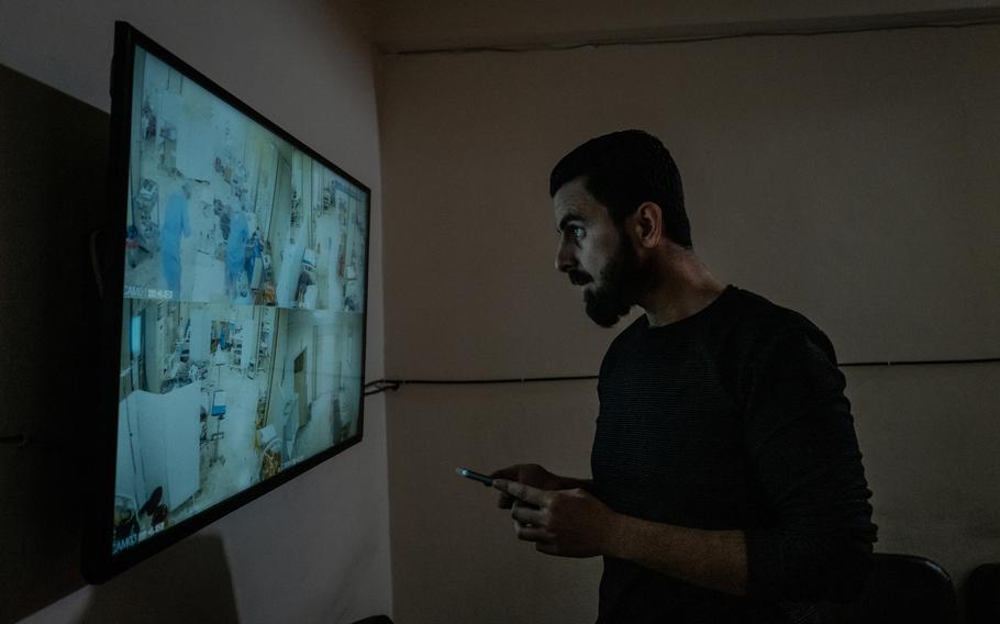 Ibrahim Abboud, 30, monitors security-camera footage of the covid ICU at al-Ziraa Hospital on Oct. 16, 2021. His mother, Amal, was among the critically ill patients. 