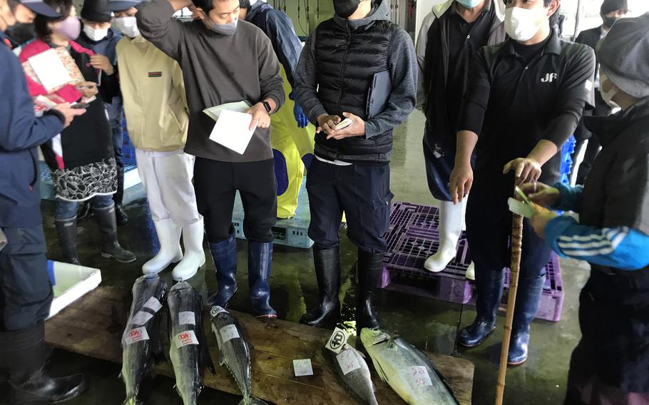 Bidders vie for the best catch from the pierside market at Meitsu Port in Miyazaki prefecture, Japan.