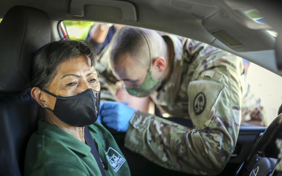 Spc. Michael Marsh of the Guam National Guard gives a COVID-19 vaccination shot to a member of the community at Guam's Port Authority in Piti, June 2, 2021. 