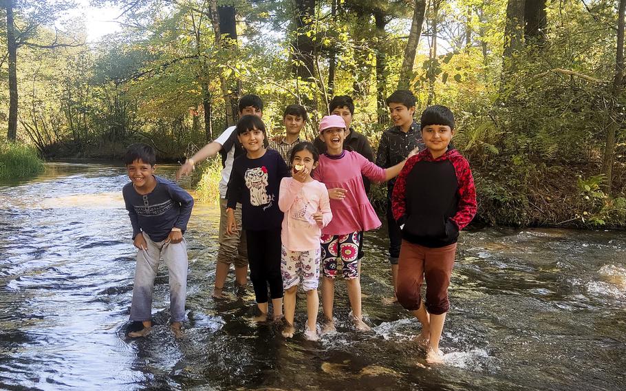 Afghan children play in a stream at Fort McCoy, Wis., Sept. 28, 2021. 