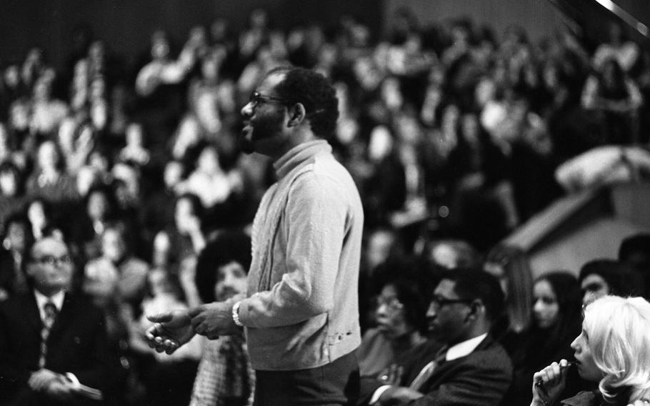 An audience member poses a question to authors James Baldwin and Chester Himes at the “Black Literature Night” and “Discussion of the Racial Situation in America and Europe” at the packed Liederhalle in Stuttgart, Feb. 16, 1973. 
