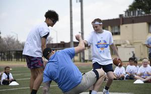 Atlanta Falcons defensive end Morgan Fox is helped to his feet during a youth football camp.