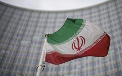 A national flag of Iran waves in front of the building of the International Atomic Energy Agency, IAEA, in Vienna, Austria, Friday, Dec. 17, 2021. (AP Photo/Michael Gruber)
