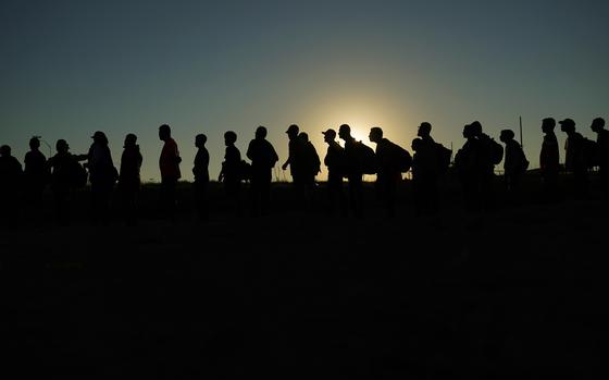 Migrants who crossed the Rio Grande from Mexicao into the U.S. are lined up for processing by U.S. Customs and Border Protection in Eagle Pass, Texas, in September 2023.