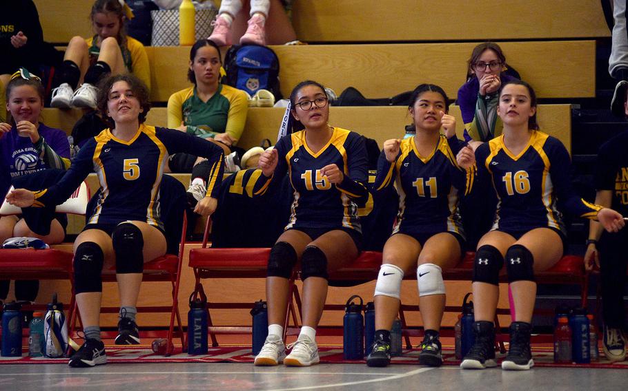 From left, Ansbach's Emily Jones, Victoria Ortiz-Cardenas, Marga Marzan and Abbi Ackles cheer from the bench in a matchup with Brussels during pool-play action of the DODEA European volleyball championships on Oct. 26, 2023, at Kaiserslautern High School in Kaiserslautern, Germany.