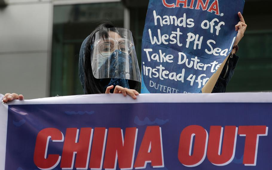 Protesters hold slogans during a rally outside the Chinese consulate in Manila, Philippines on May 7, 2021.