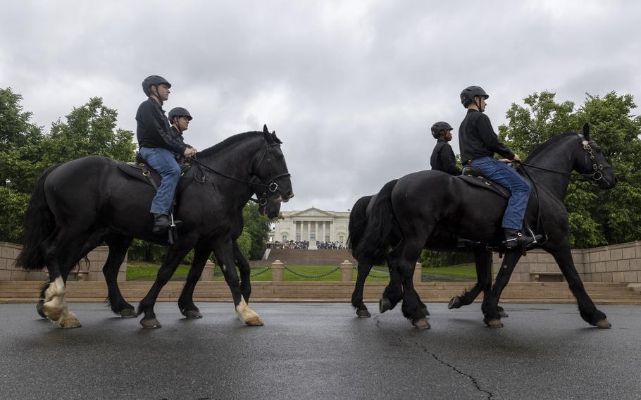 Soldiers train with their horses. Arlington House is in the background.