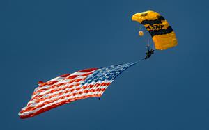 Member of the U.S. Army Parachute Team (USAPT), Sgt. 1st Class Joshua Evans, flies the American Flag onto Miami Beach on May 23, 2025 in advance of the Hyundai Air and Sea Show in Miami, Florida. The Hyundai Air and Sea Show is held annually on Memorial Day Weekend in Miami, Florida, and hosts performances by different military demonstration teams. The Golden Knights conduct demonstration jumps across the country to connect the American People to America's Army. (U.S. Army Photo by Spc. Mari Kossman)