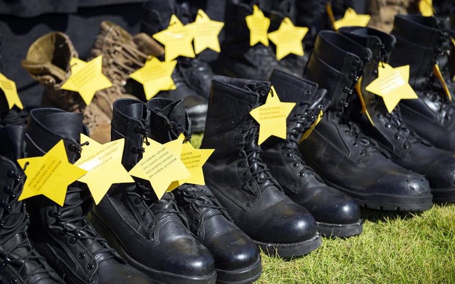 Boots representing fallen sailors are displayed during a Bells Across America ceremony at Yokosuka Naval Base, Japan, Thursday, Sept. 23, 2021. 