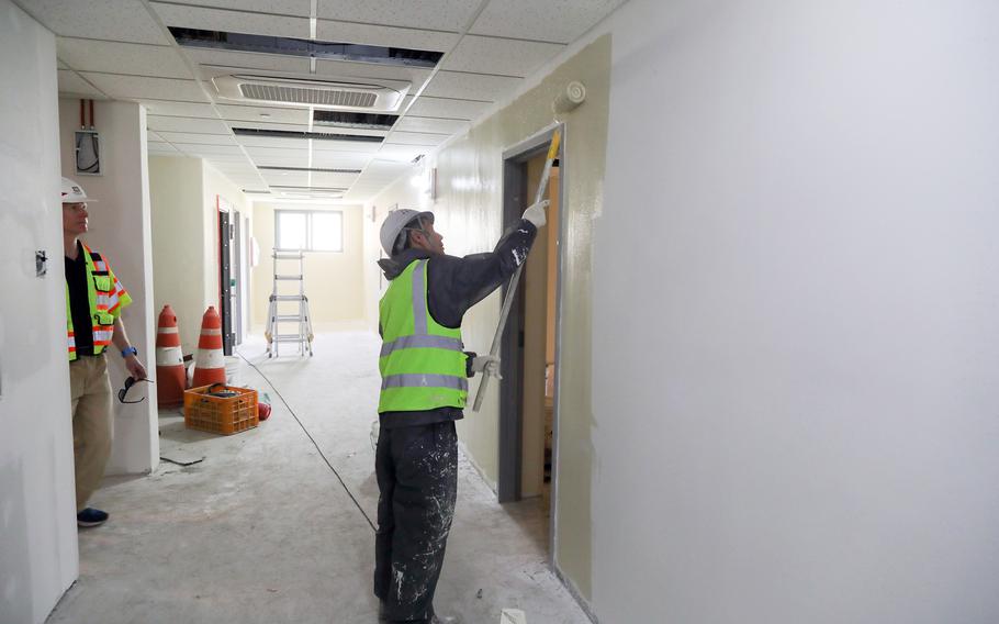 A worker paints the wall.