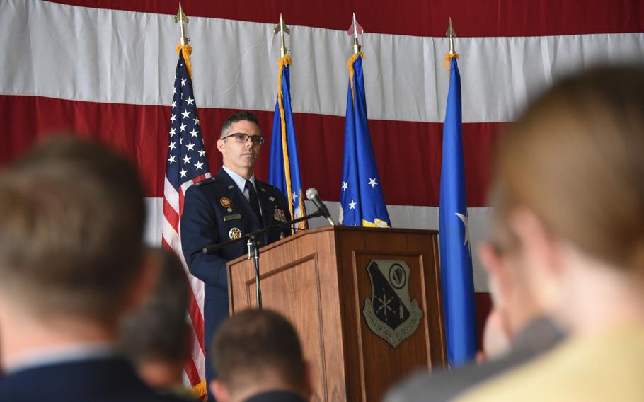 A man speaking at a podium emblazoned with the insignia of the 185th Air Refueling Wing.