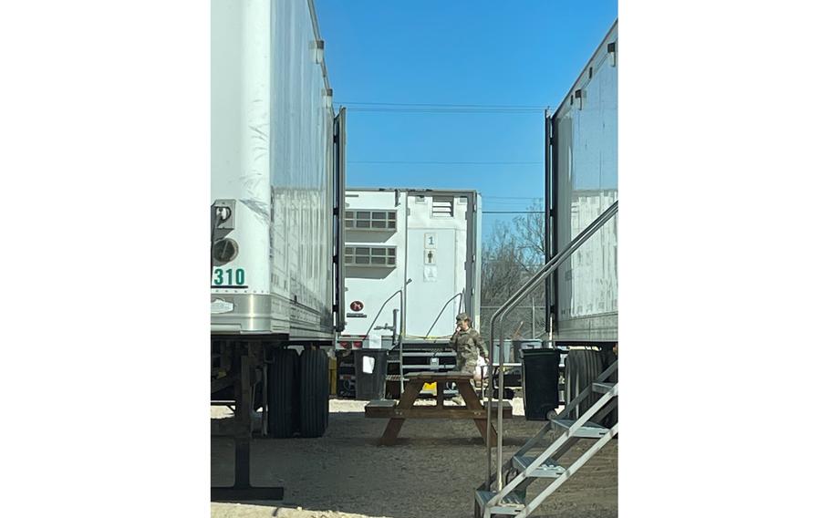 A soldier walks through a row of bed trailers at Base Camp Walker in Laredo, Texas, on Feb. 13, 2022. Each trailer can house up to 36 soldiers in three-tiered bunk beds.