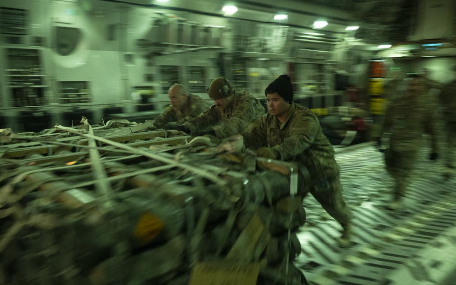 Airmen unload munitions from a C-17 Globemaster III assigned to the 816th Expeditionary Airlift Squadron at Al Asad Air Base, Iraq, Dec. 6, 2021. 