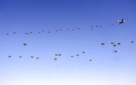 Paratroopers jump from a Japan Air Self-Defense Force Kawasaki C-2 Greyhound over Camp Narashino in Chiba prefecture, Japan, Sunday, Jan. 8, 2023. 