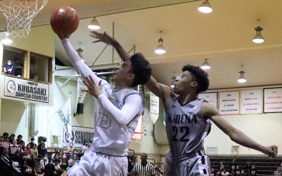 Kubasaki's Erick Camacho drives to the basket ahead of outstretched Chaz Conley of Kadena during Thursday's Okinawa basketball game. The Dragons rallied to win 47-37.