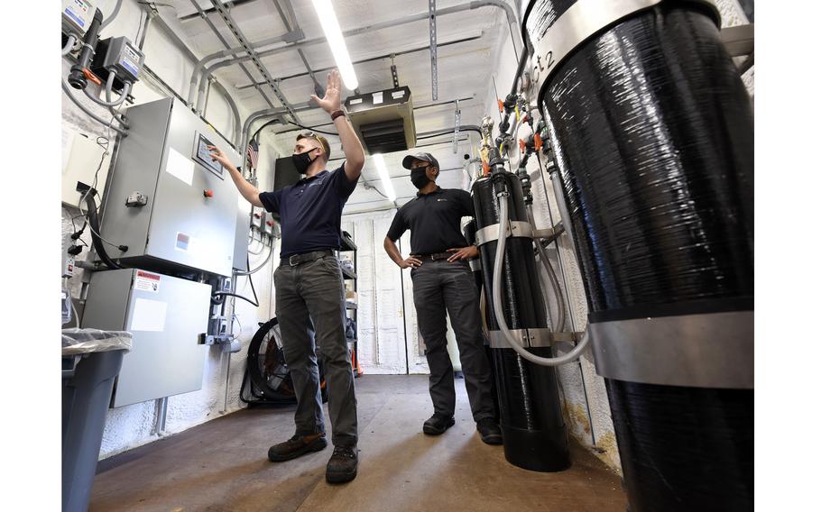 Dan Casey, left, lead field operations engineer, and Brad Geisman, pilot engineer for Emerging Compounds Treatment Technologies (ECT2), discuss a water filtration system being used to remediate polyfluoroalkyl substances (PFAS) from contaminated groundwater at the fire training area of Wright-Patterson Air Force Base, Ohio on Sept. 29, 2020. 