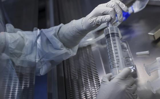 An employee prepares a syringe of raw materials for messenger RNA, the first step of Covid-19 vaccine production, at the BioNTech laboratory in Marburg, Germany, on March 27, 2021. MUST CREDIT: Bloomberg photo by Cyril Marcilhacy.