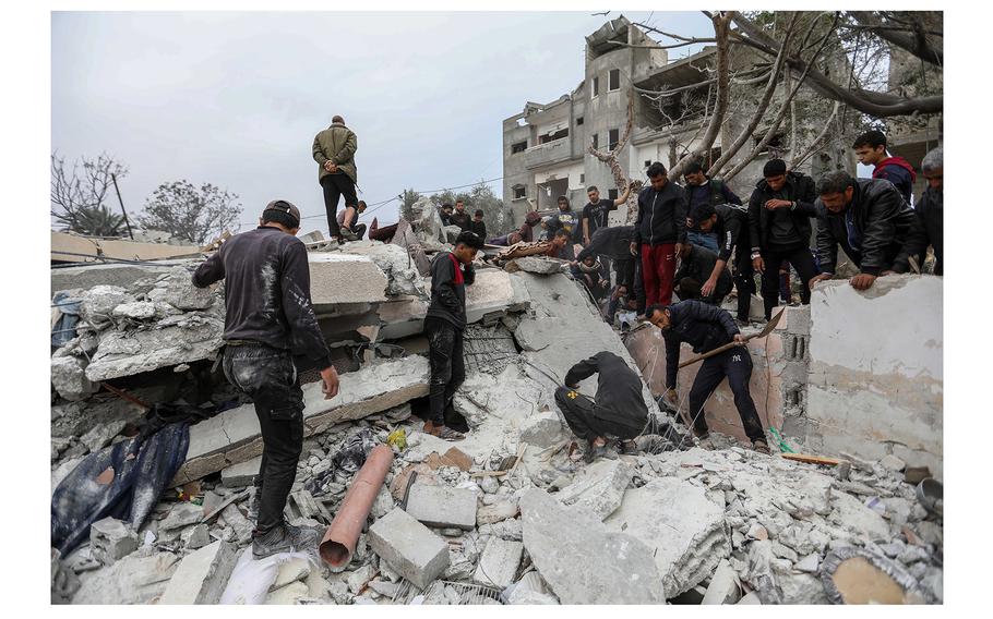People recover the body of a child from a destroyed building following Israeli air strikes on March 29, 2024, in Rafah, Gaza. Overnight, Israel launched rockets southeast of Aleppo, where at least 42 died, including six Hezbollah fighters.