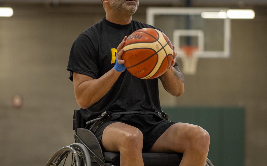 An Army service member shooting a basketball from a wheelchair.