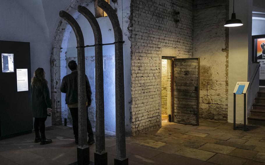 Visitors examine wall carvings left by prisoners when the castle's basement served as temporary holding cells for the Gestapo at the Saar Historical Museum in Saarbruecken, Germany, on Oct. 19, 2023. The carvings bear witness to the resilience of those who were unjustly imprisoned, leaving a lasting impression on visitors.