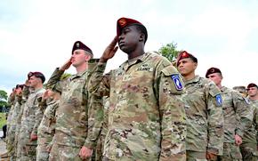 Soldiers salute in formation.