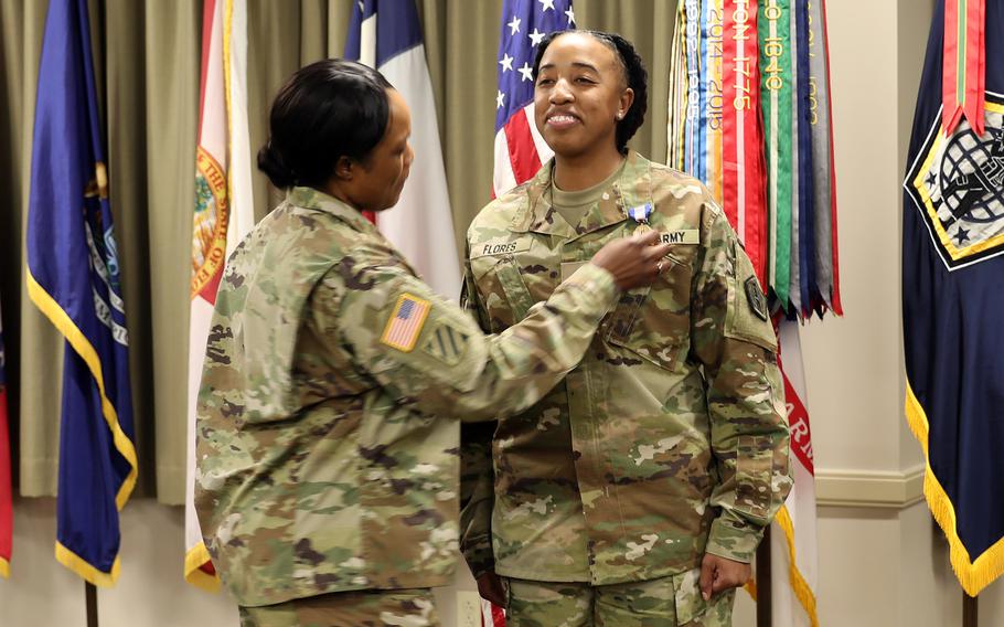 Army Col. Jeanette Martin, left, pins the Soldier’s Medal on Staff Sgt. Aschlynd Spidell-Flores on Oct. 20, 2023, at Fort Knox, Ky. Spidell-Flores was honored for risking her life to pull a woman out of her smoldering car following a crash on Oct. 3, 2022.