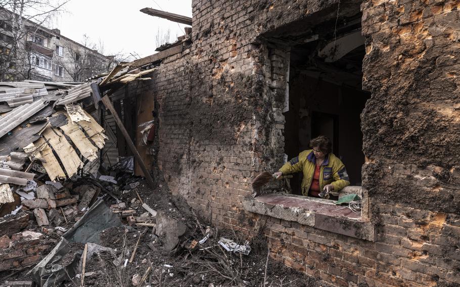 Maria Starovoitovyi uses a broom to sweep away the debris of the window of her heavily damaged home after a shelling attack in the city of Kostyantynivka in the Donetsk region of eastern Ukraine on April 2. 