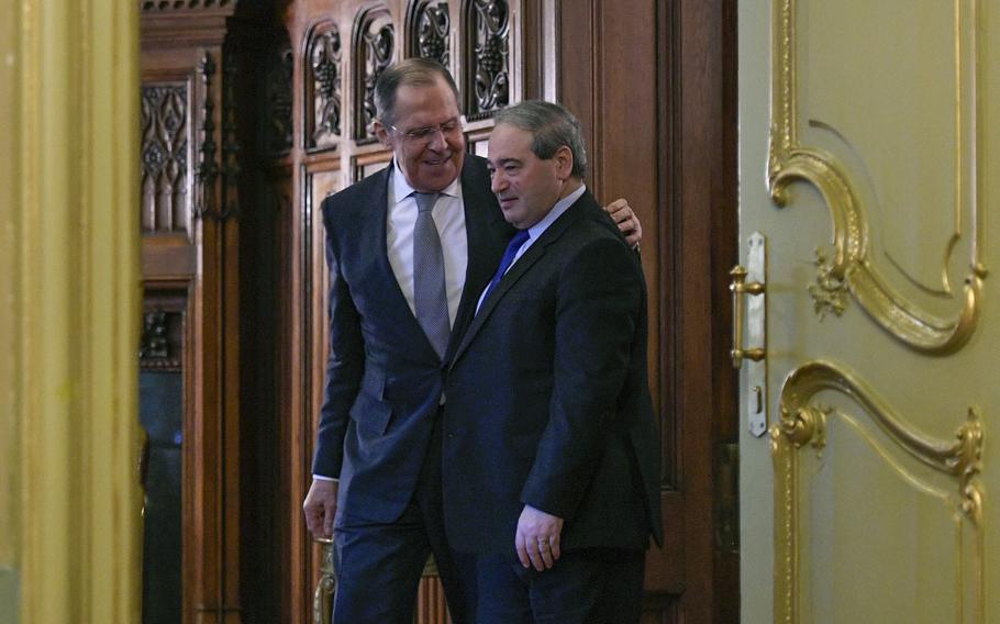 Russian Foreign Minister Sergey Lavrov, left, and Syrian Foreign Minister Faisal Mekdad enter a hall for a news conference following their talks in Moscow, on Feb. 21, 2022.