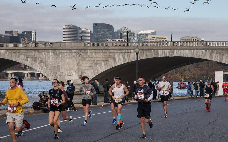 Geese fly overhead as competitors in the Marine Corps Marathon run along the Potomac River Sunday in Washington, D.C.
