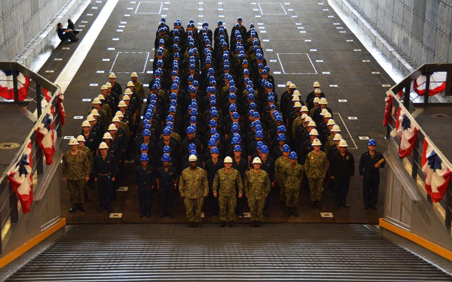 Pre-Commissioning Unit Fort Lauderdale (LPD 28) Commanding Officer Capt. James Quaresimo (front center), Command Master Chief James Magee (front left) and Acting Executive Officer Cmdr. Charles Marshall pose with the crew in the well deck after accepting delivery of the ship. Delivery marks the official transfer of the ship from the shipbuilder to the Navy.
