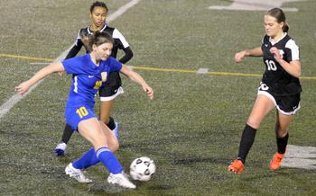 Yokota’s Lucy Wellons boots the ball against Zama‘s Madison Anderson and Olivia Parish during Friday’s DODEA-Japan girls soccer season opener at Yokota’s Fred Bonk Memorial Field. The Panthers won 2-0.