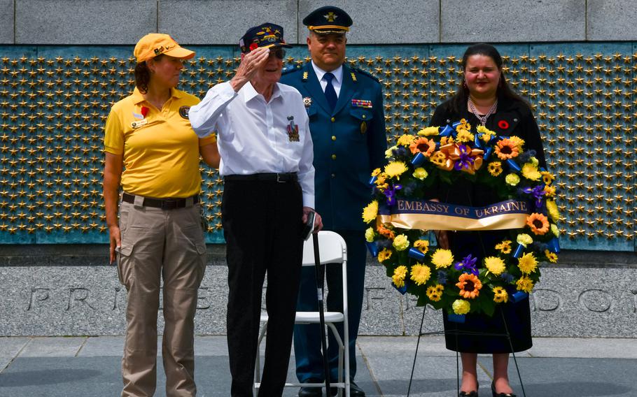 Retired Senior Master Sergeant Harry F. Miller stands and salutes