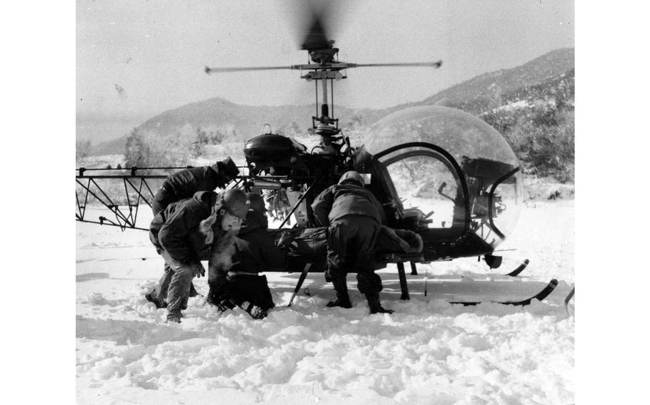 A “wounded” soldier is strapped to the landing skids of an H-13 helicopter.