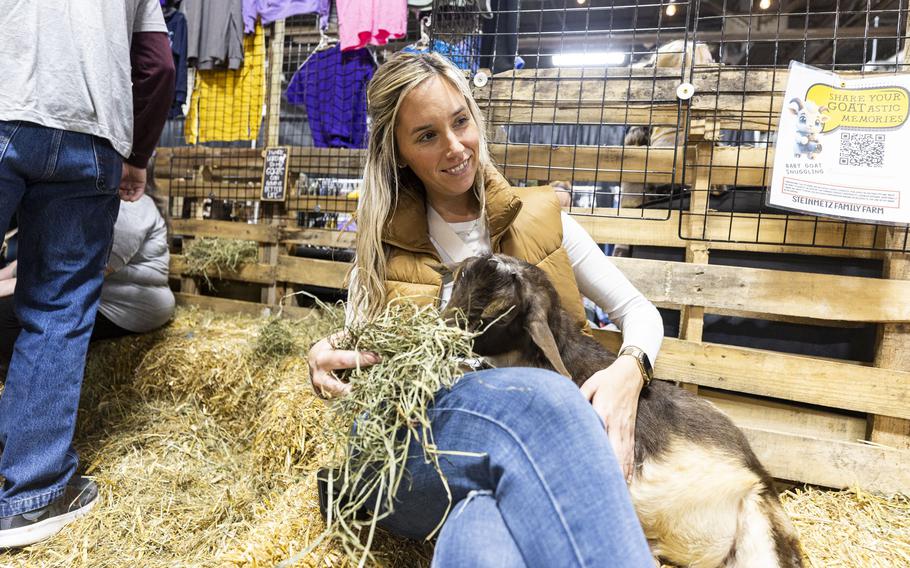 Amy Ketterer, of Greenlane, Pa., pets a baby goat during her visit with her daughter to the Steinmetz Family Farm booth at the Pennsylvania Farm Show in Harrisburg on Jan. 10. Lauren Steinmetz calls the “snuggling station” a lifeline for the farm. “It got to the point where we had to start making money with these animals or we had to get rid of them,” Steinmetz said.