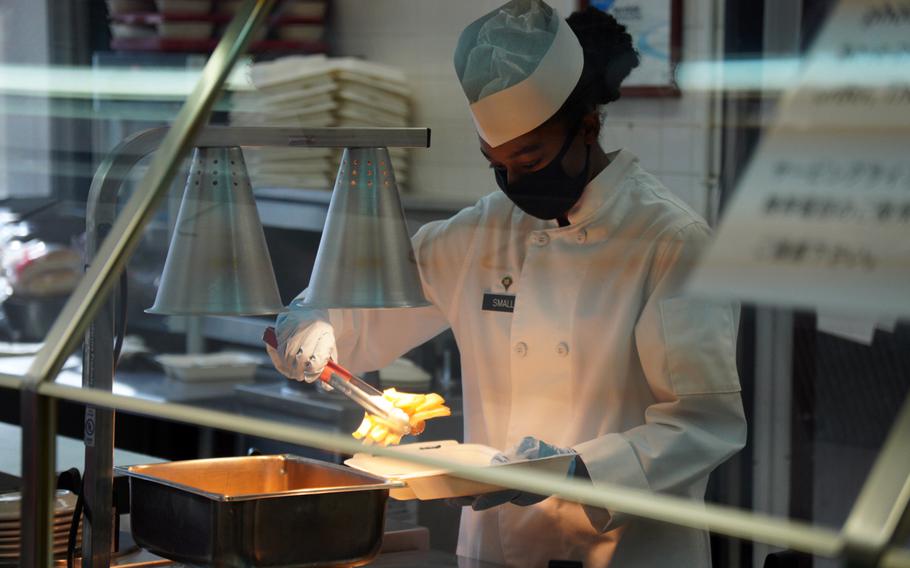 Army culinary specialist Kimyatte Small wears a mask while serving food at Camp Zama, Japan, Feb. 3, 2022. 