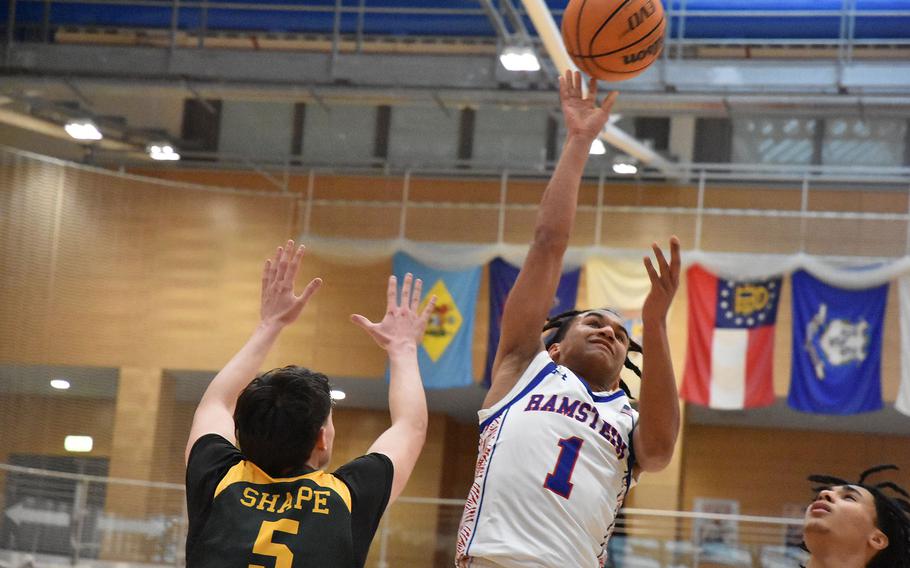 Ramstein’s Christan Roy puts up a shot Thursday, Feb. 15, 2024, before SHAPE’s Bela Clobes can get to him at at the DODEA European Division I Basketball Championships at Wiesbaden, Germany.