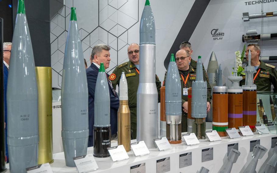 Belarusian military officers view heavy rounds on display at the Russian pavilion during the International Defence Exhibition at the Abu Dhabi International Exhibition Centre on Feb. 20, 2023.