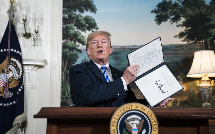 President Donald Trump signs a National Security Presidential Memorandum as he announces the withdrawal of the United States from the Iran nuclear deal in May 2018.