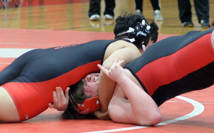 Braden Askins grimaces under a reverse chest press by Nile C. Kinnick teammate Kaleb Leon Guerrero in the 215-pound final. Leon Guerrero pinned Askins in 38 seconds.