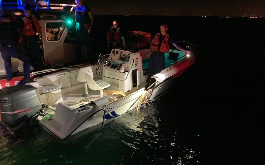 In this image provided by the U.S. Coast Guard, a Coast Guard Station Miami Beach small boat crew inspects a boat that was part of a collision near Key Biscayne, Fla., late Friday, June 17, 2022. The Coast Guard, Miami-Dade Fire Rescue, Miami-Dade Police Department, and Florida Fish and Wildlife crews assisted 10 people and recovered two bodies after their vessels collided.