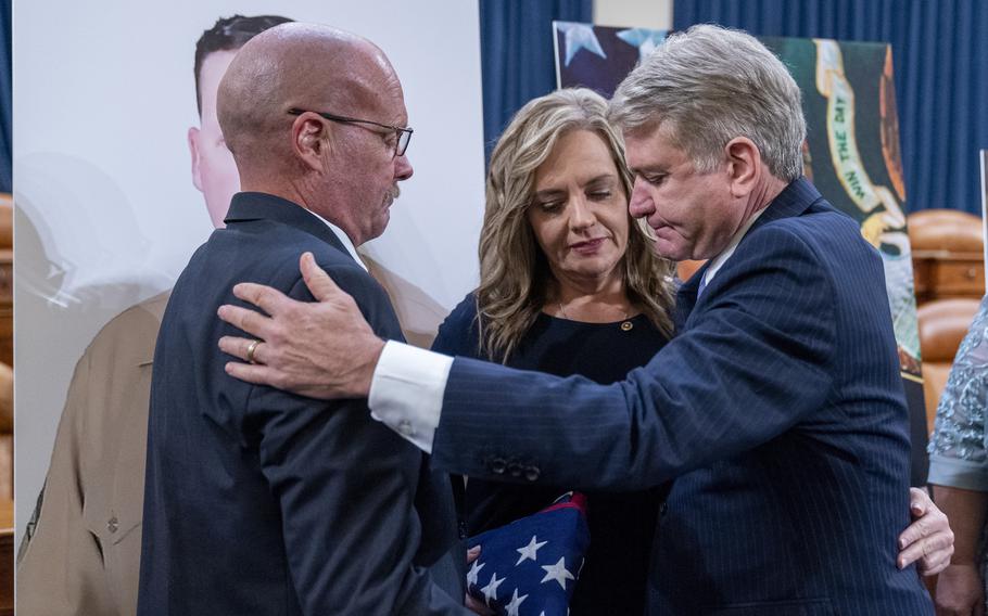 Darin Hoover, left, and Kelly Barnett, parents of Marine Corps Staff Sgt. Taylor Hoover and Abbey Gate Gold Star family members, embrace Rep. Michael McCaul, R-Texas, who presented them with a flag flown over the U.S. Capitol on Aug. 26, 2023, after a House Foreign Affairs Committee roundtable discussion Tuesday, Aug. 29, 2023, on Capitol Hill in Washington. 