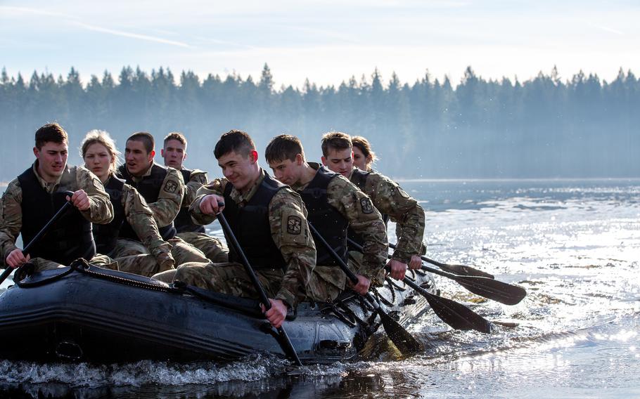 Army Cadets paddle a zodiac boat.