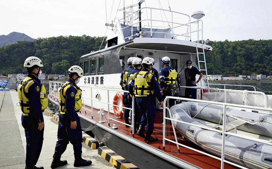 Hokkaido prefectural police officers board a patrol boat for a search operation Thursday, Aug. 18, 2022.