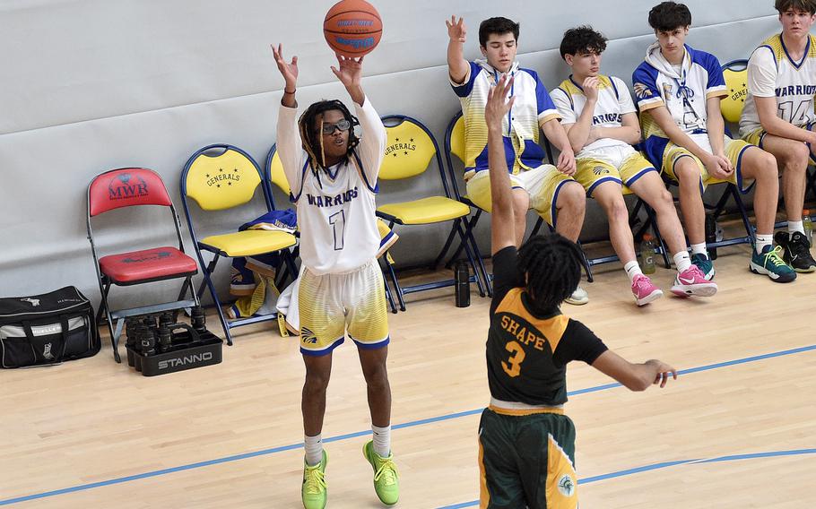 WIesbaden junior Jordan Thibodeaux shoots over SHAPE senior Yanis Anderson during pool-play action of the DODEA European basketball championships on Feb.14, 2024, at the Wiesbaden Sports and Fitness Center on Clay Kaserne in Wiesbaden, Germany.