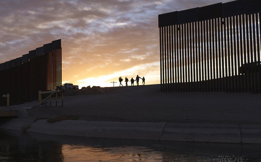 A pair of migrant families from Brazil pass through a gap in the border wall to reach the United States after crossing from Mexico to Yuma, Ariz., on June 10, 2021. Border officials got the go-ahead Thursday, July 28, 2022, to fill four remaining gaps in the U.S.-Mexico wall near the southern Arizona community of Yuma for safety reasons.