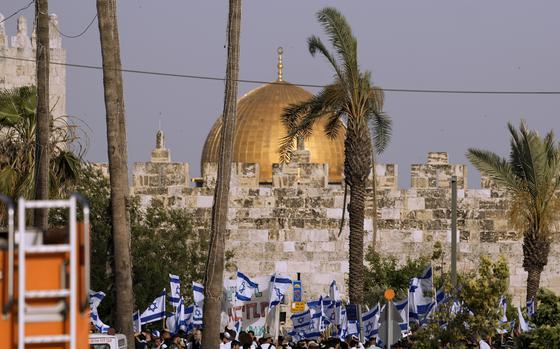 FILE - Israelis wave national flags in front of Damascus Gate outside Jerusalem's Old City to mark Jerusalem Day, an Israeli holiday celebrating the capture of the Old City during the 1967 Mideast war, Sunday, May 29, 2022. The ruling Hamas militant group in the Gaza Strip on Wednesday, May 17, 2023, called on Palestinians to confront a flag-waving parade planned by Jewish nationalists through the main Palestinian thoroughfare in Jerusalem’s Old City.(AP Photo/Ariel Schalit)