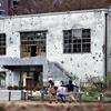 Children play in front of a former substation building with countless bullet marks at a park in Higashiyamato, Tokyo. 